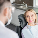 Blonde white female patient smiles as she sits in a dental chair at her dentist in Hot Springs Village, AR