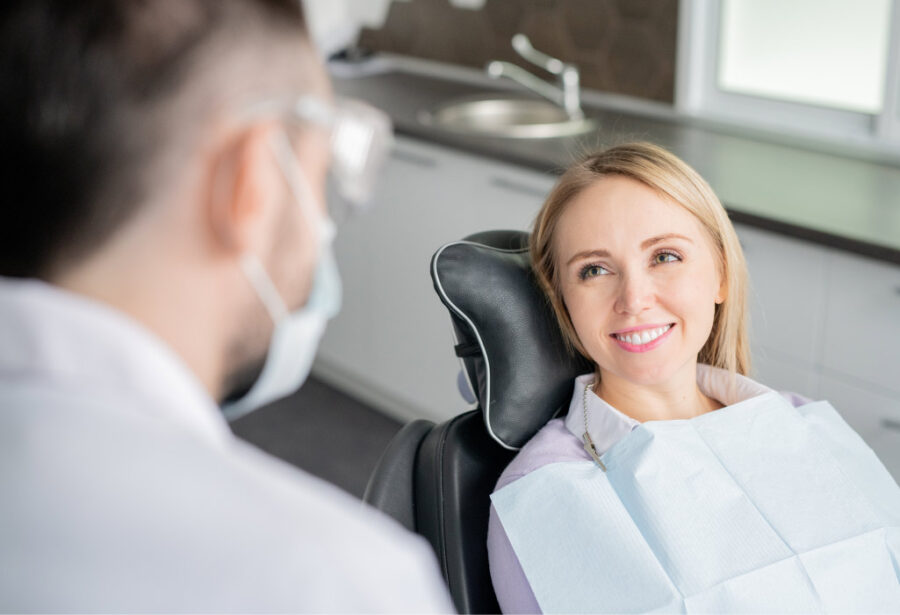 Blonde white female patient smiles as she sits in a dental chair at her dentist in Hot Springs Village, AR