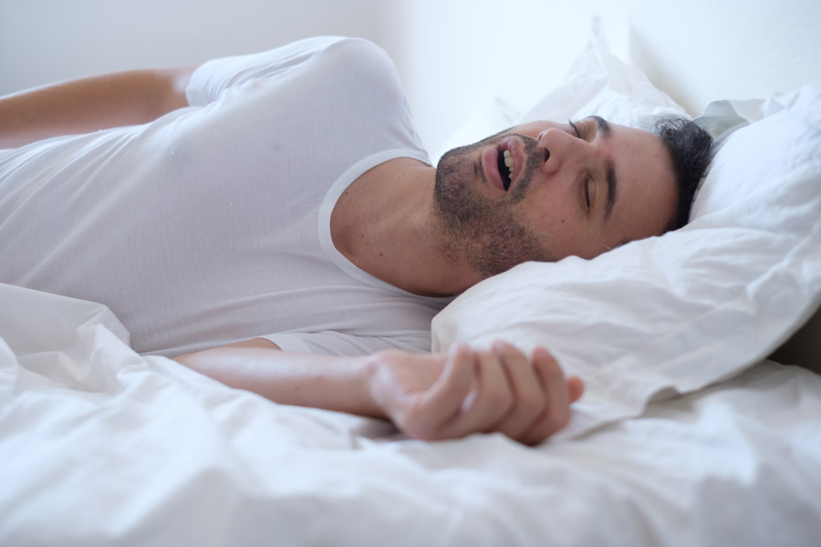 sleeping man snores because of sleep apnea