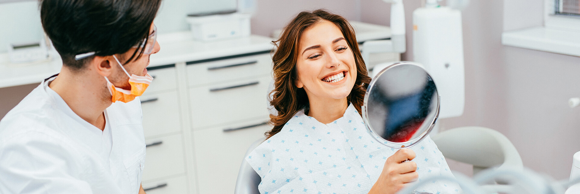 woman examining her smile in a mirror
