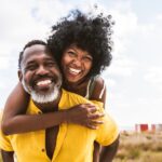 smiling couple after smile restoration with prosthodontics